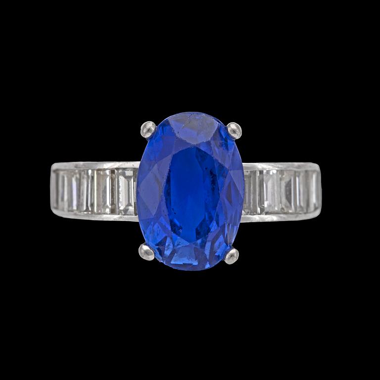 RING, oval fasettslipad blå safir, ca 6 ct, med baguetteslipade diamanter, tot. ca 1.50 ct.