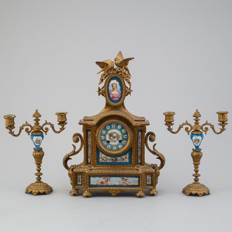 A table clock and two candelabras from the late 19th century.