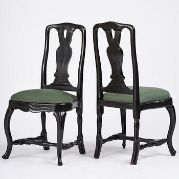 A set of eight black Swedish rococo chairs.