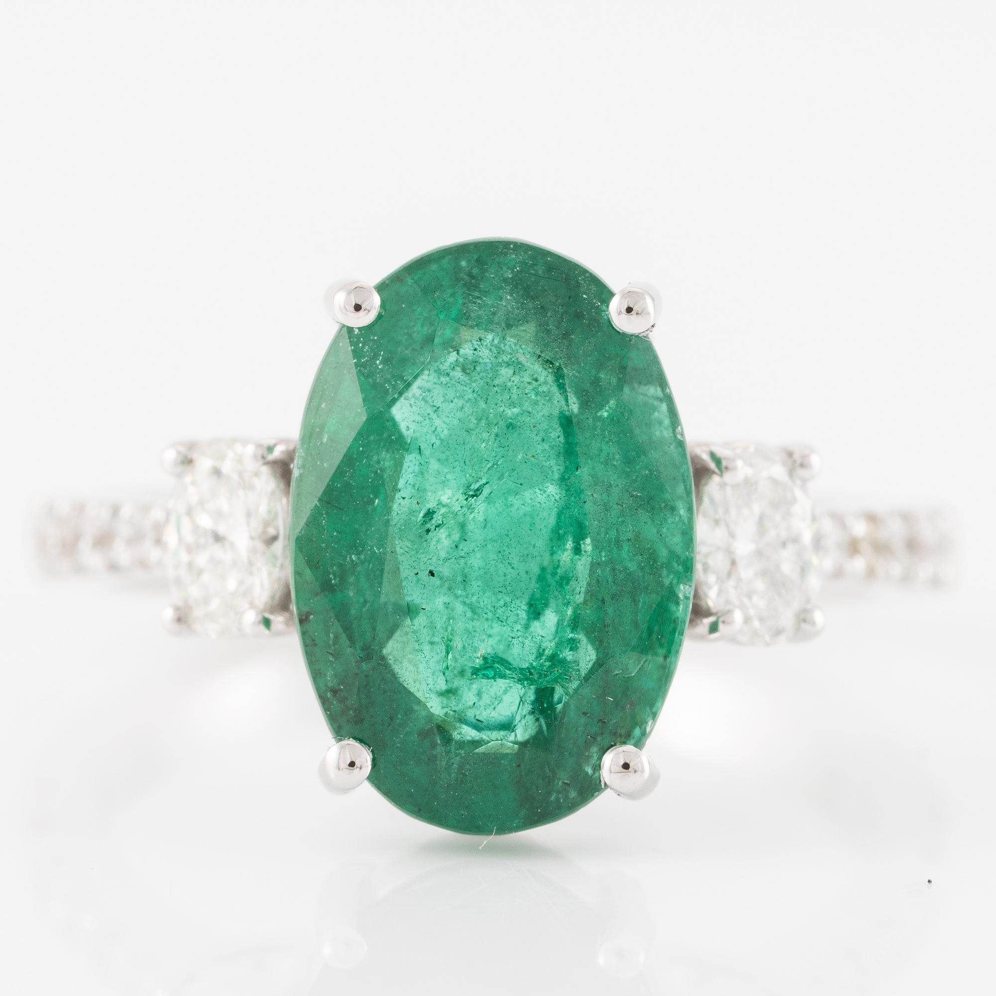 Ring in 18K white gold with an oval emerald and oval-cut and brilliant-cut diamonds.
