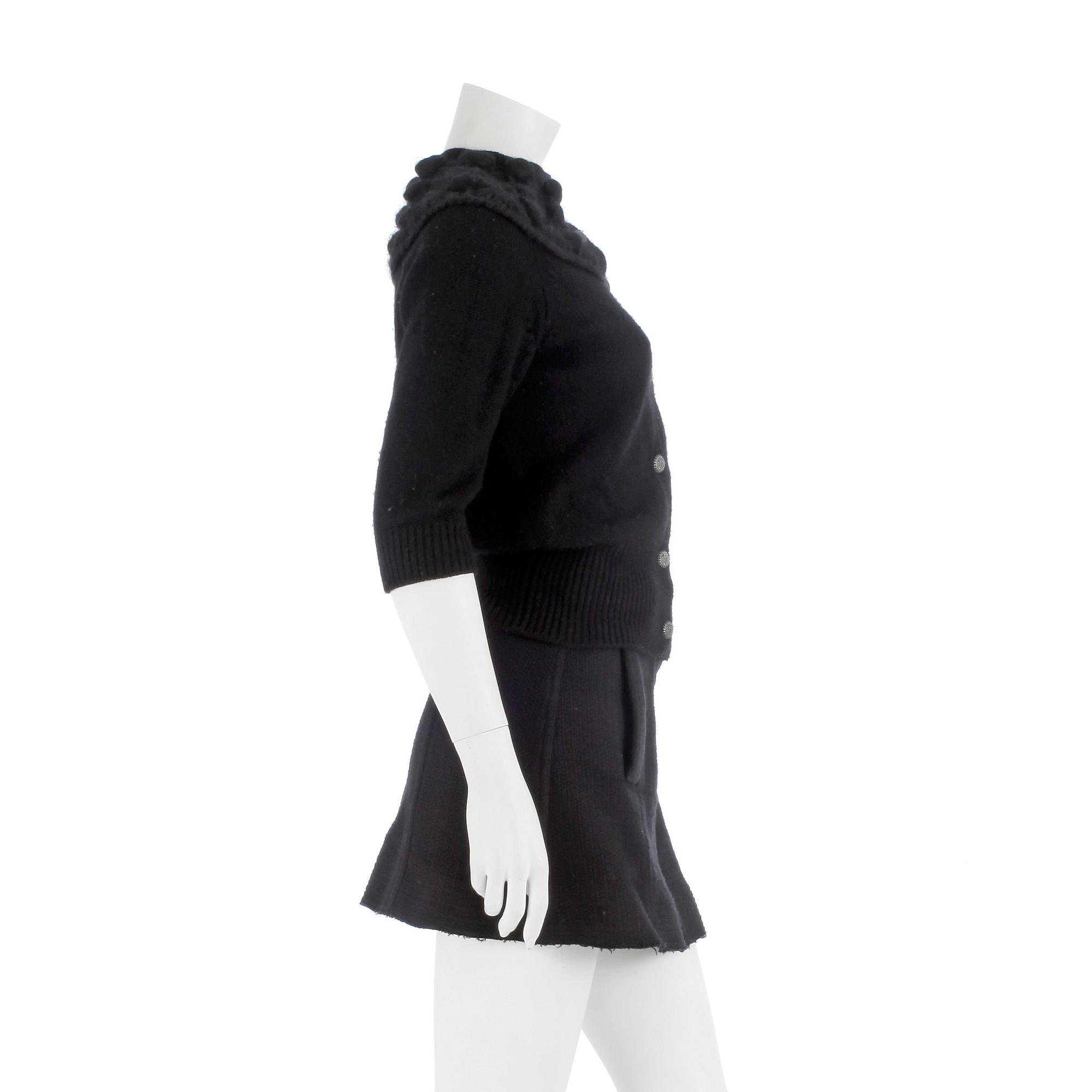 CHANEL, a black cashmere carding and a bouclé skirt.