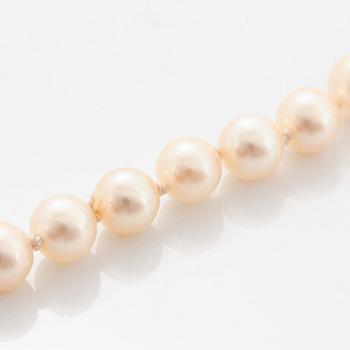 A cultured pearl necklace with a bow clasp in 18K gold set with round brilliant-cut diamonds.