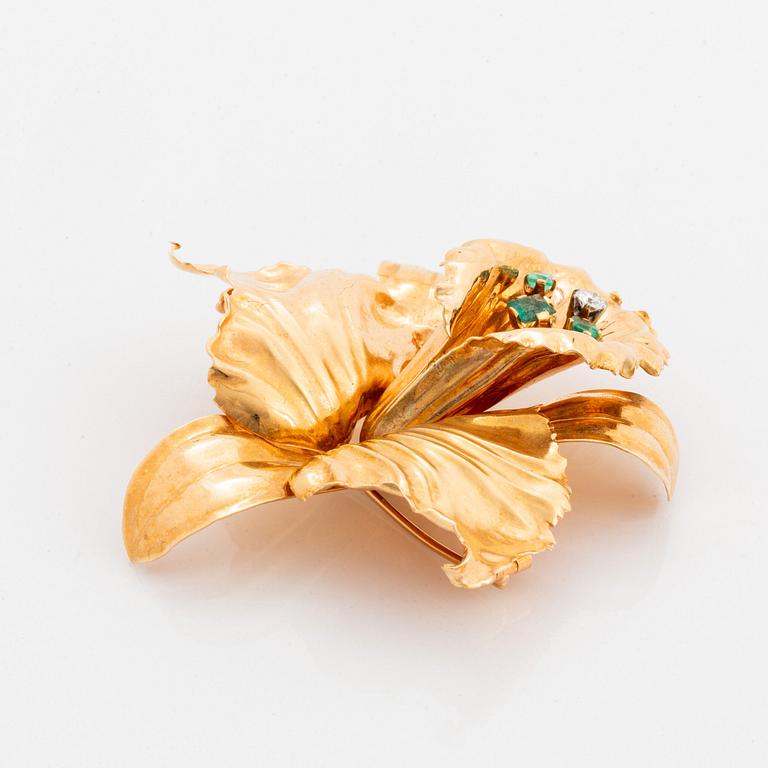 Brosch 18K guld med en rund briljantslipad diamant och fasettslipade smaragder.