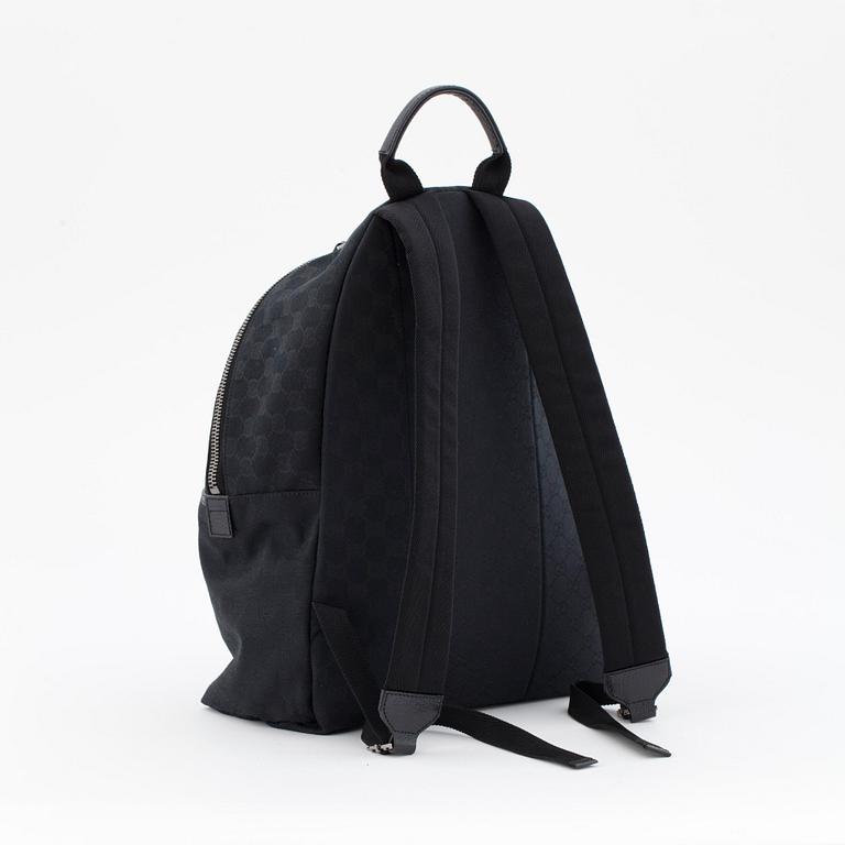 GUCCI, a black monogramed canvas backpack.