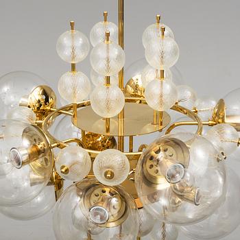 A 1970s brass ceiling light with glass shade. Height ca 144.