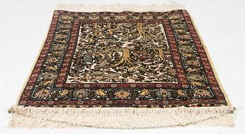 A figural silk Hereke rug, signed c. 92 x 61 cm.