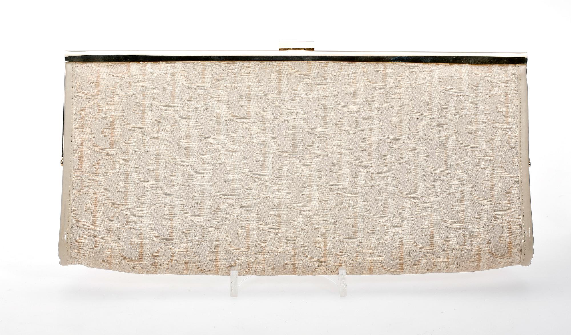 A white monogram canvas clutch by Christian Dior.