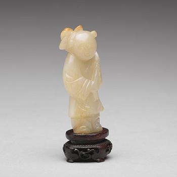 A carved nephrite figure of a boy with a lotus branch, Qing dynasty (1644-1912).