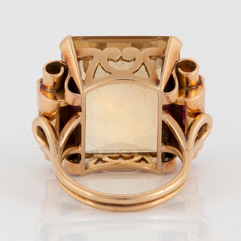 A 14K gold ring set with a faceted citrine and rubies.