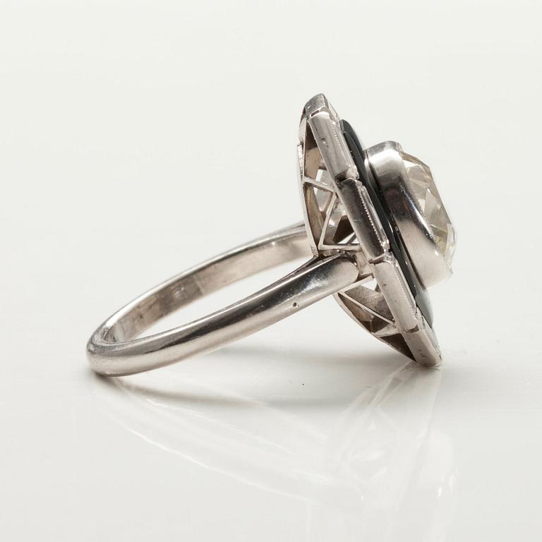 SORMUS,  platinaa, onyx. Cushionhiottu timantti 5.20 ct + baguettehiottuja timantteja n. 2 ct. Yhteensä 7.20 ct. Ranska.