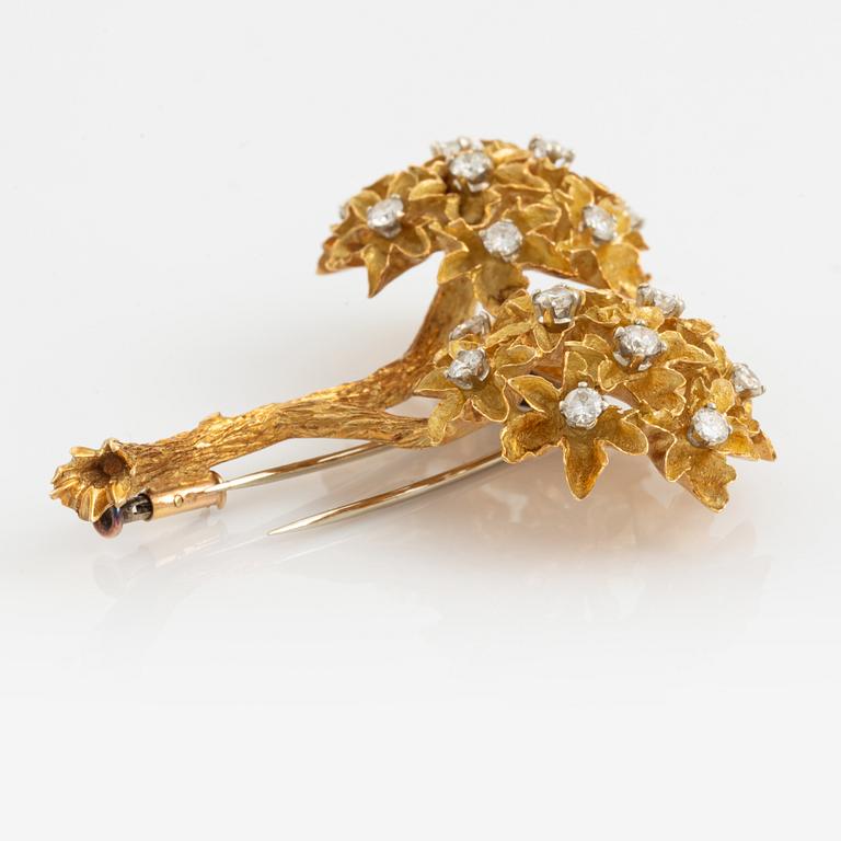 An 18K gold brooch set with round brilliant-cut diamonds.