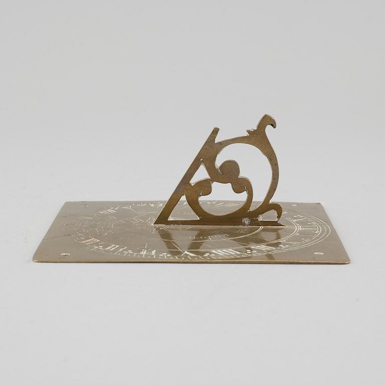 A brass sundial dated 1715.