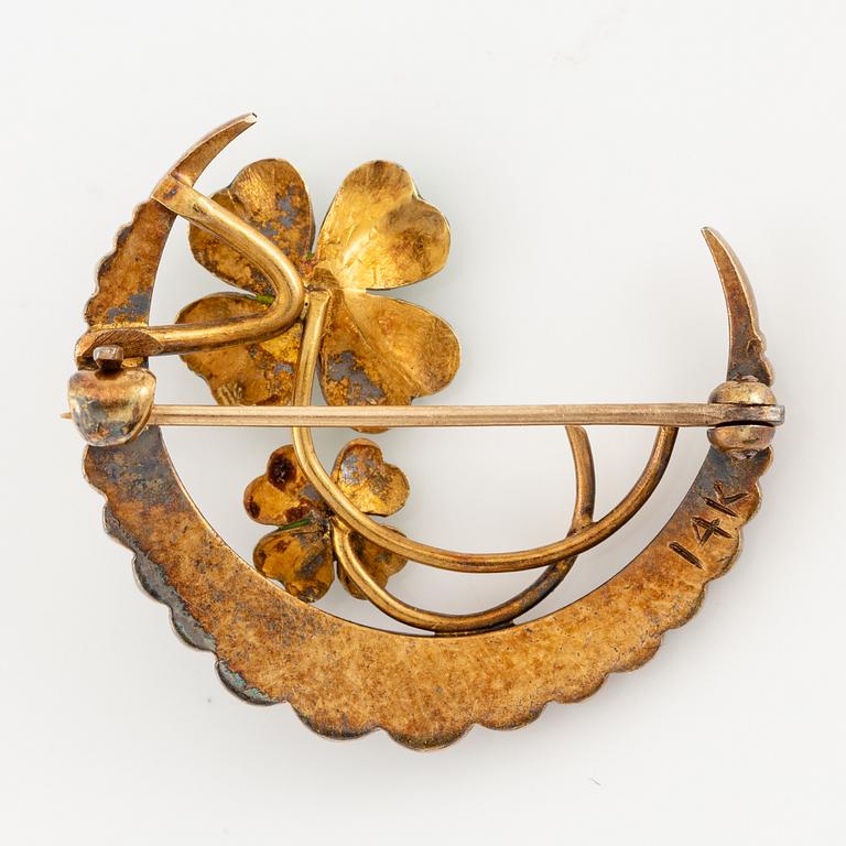 A brooch in the form of a crescent moon in 14K gold  with enamel and rose-cut diamonds.