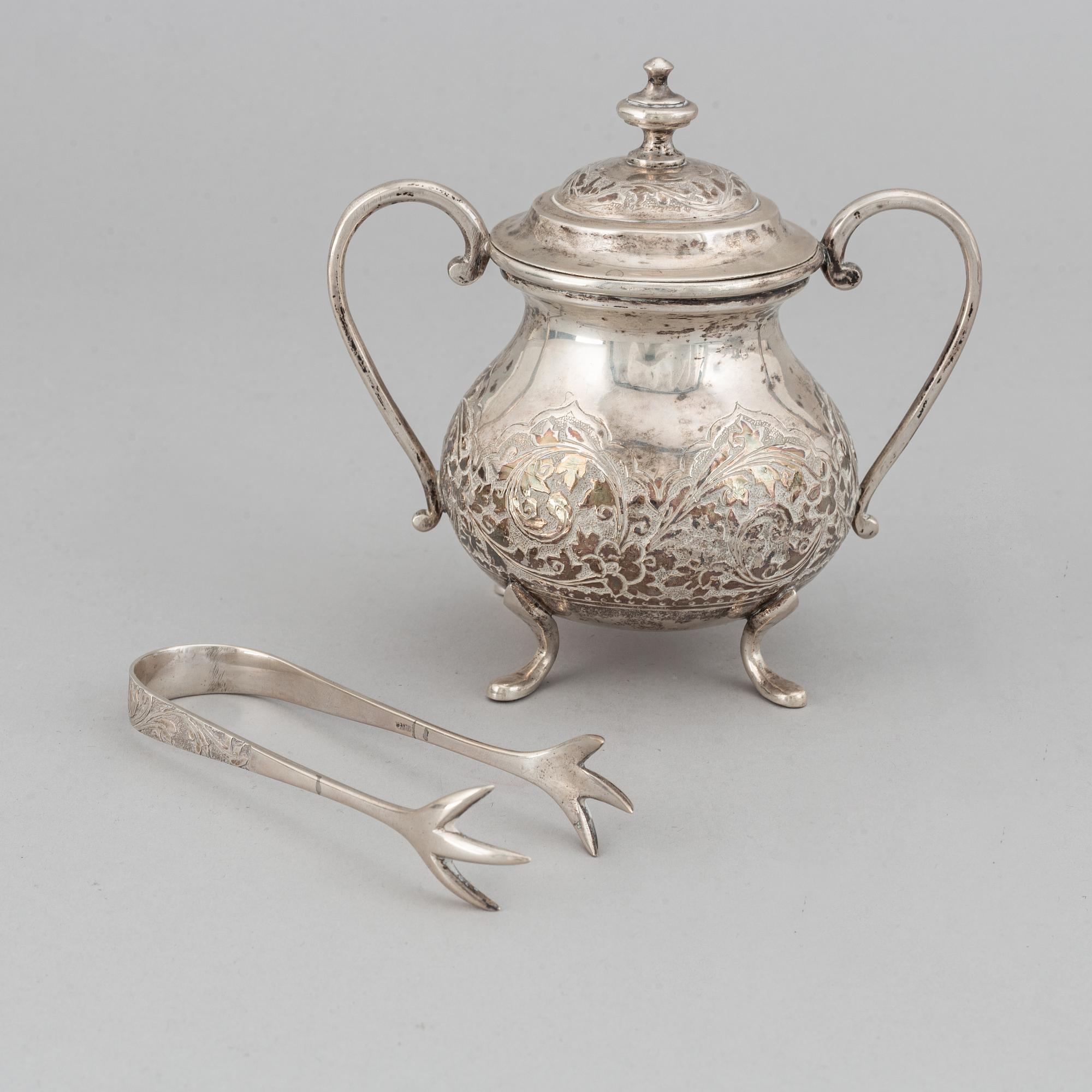 A Pakistan silver coffee pot, sugar bowl, sugar tongs and creamer.