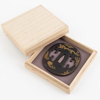 An iron part gilt Japanese tsuba, Edo (1603-1868). In a kiri box.