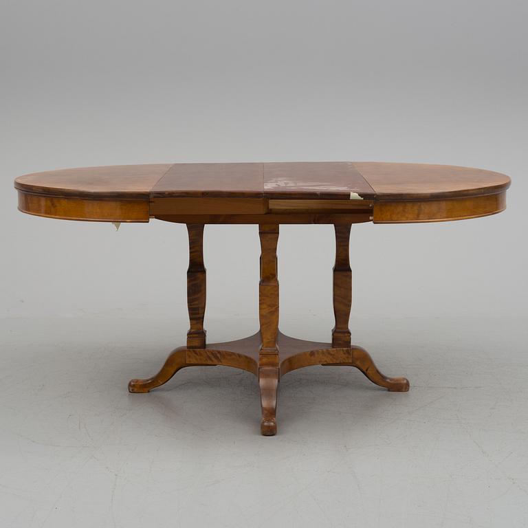 A first half of the 20th century dining table veneered with birch. With three extension leaves.