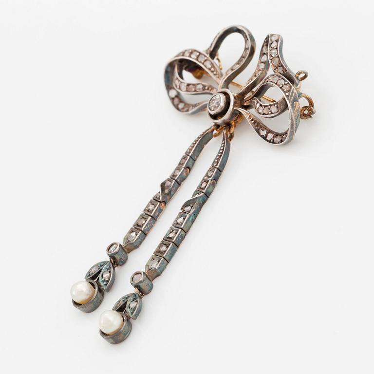 A 14K gold and silver brooch set with old- and rose-cut diamonds and two pearls.