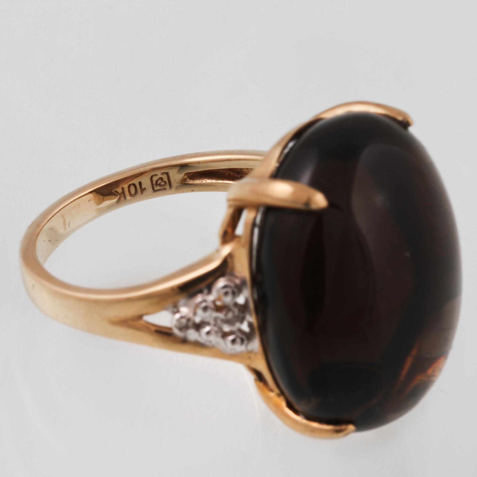 RING, 10K guld med cabochonslipad rökkvarts samt 4 åttkantsliapde diamanter. Vikt 7,2 gram.