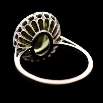 RING, fasettslipad peridot, åttkantslipade diamanter, 18K vitguld. Joensuun Kultaseppä, 1977.