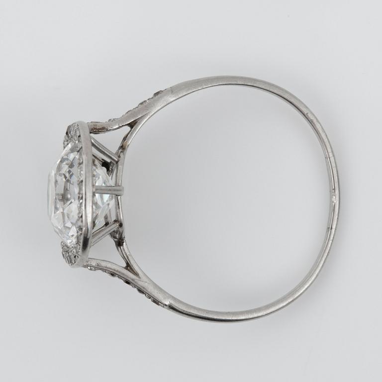 RING med en äldre kuddslipad diamant ca 3.50 ct med omgivande krans av mindre diamanter, troligen tillverkad av Cartier.