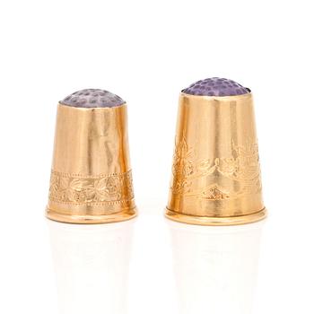 Two 18K gold thimbles with blue and lilac stones.
