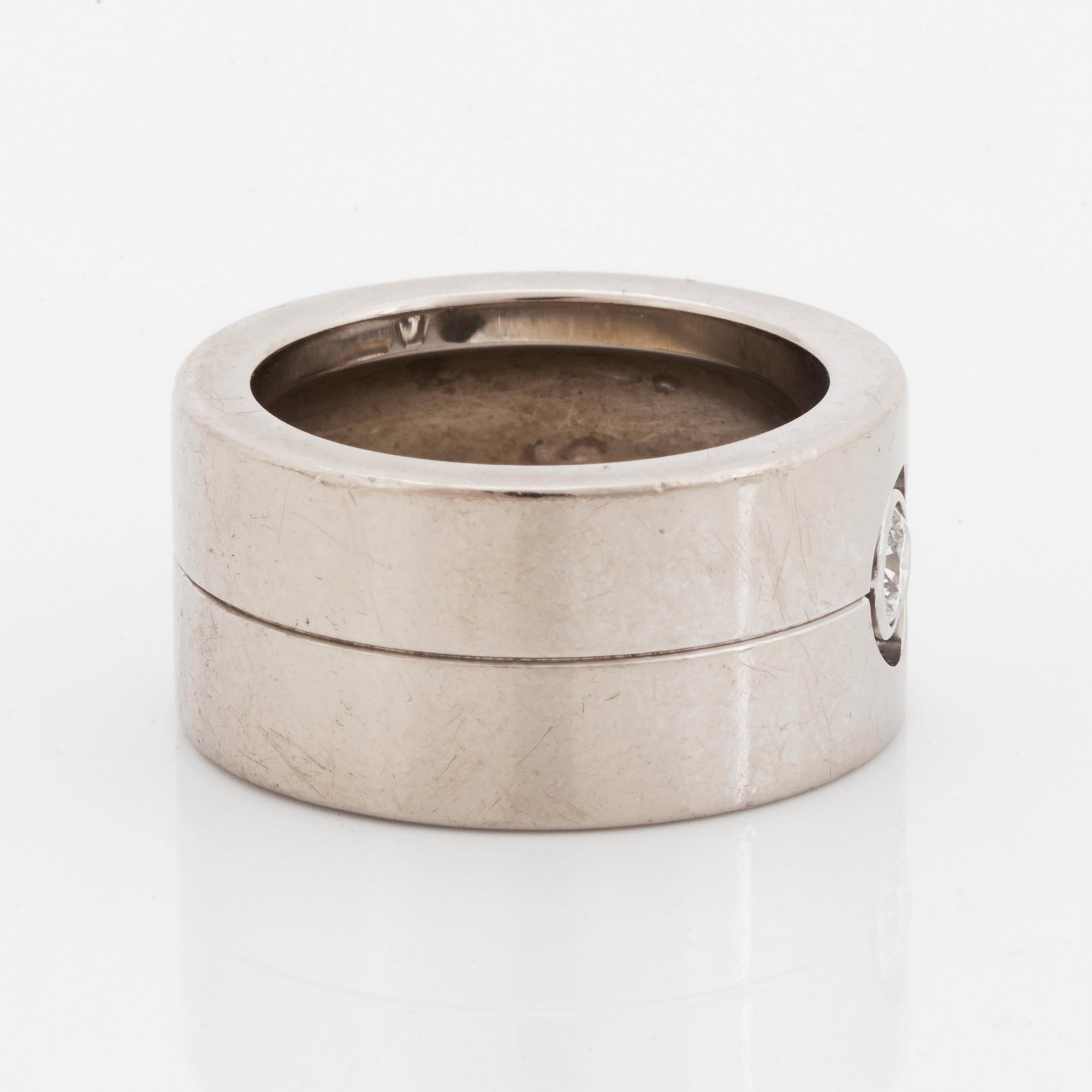 A Cartier 18K white gold ring set with a round brilliant-cut diamond.