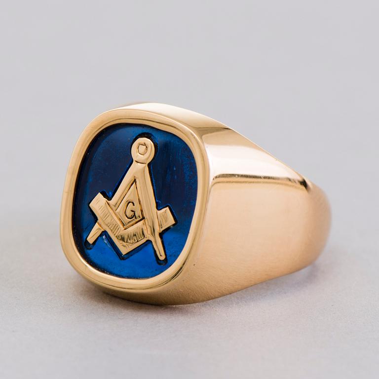 A gold 18K Freemason ring with a synthetic blue sapphire.