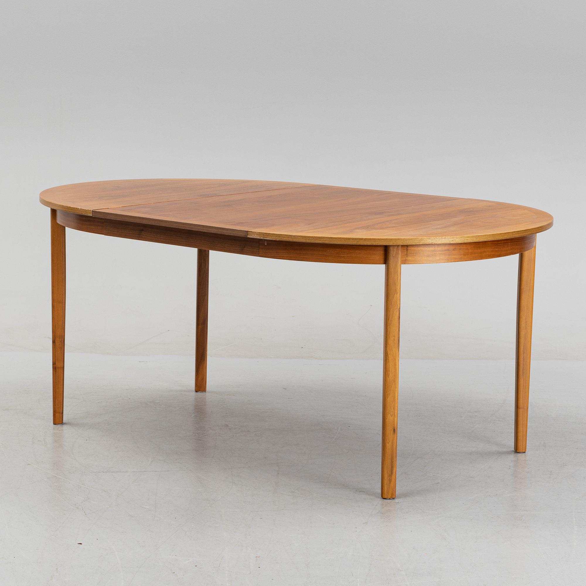 A round walnut veneered dining table.