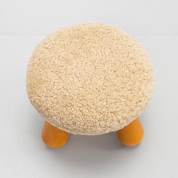 A Swedish, new produced stool with birch legs and sheepskin upholstery.