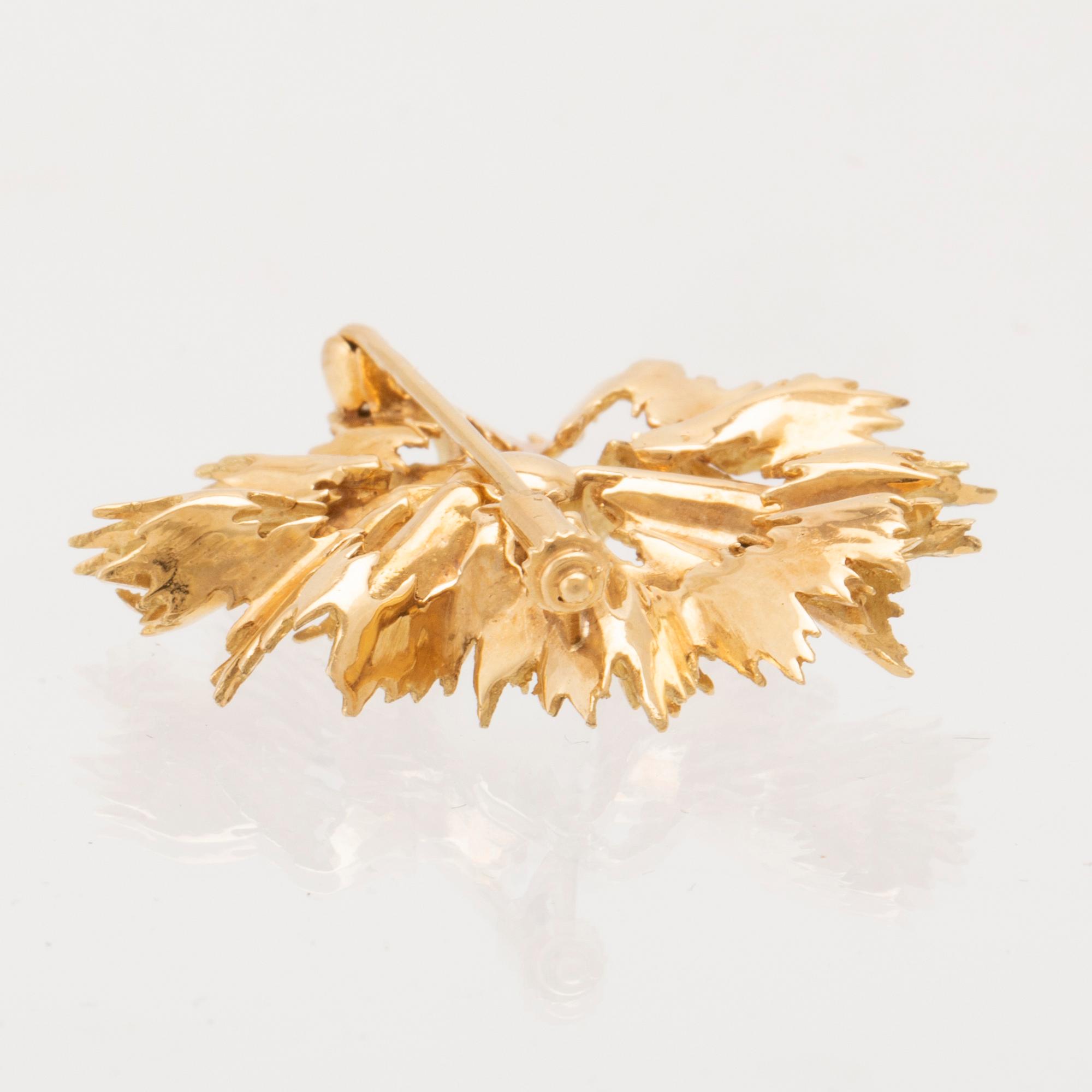 An 18K gold brooch set with a cultured pearl.