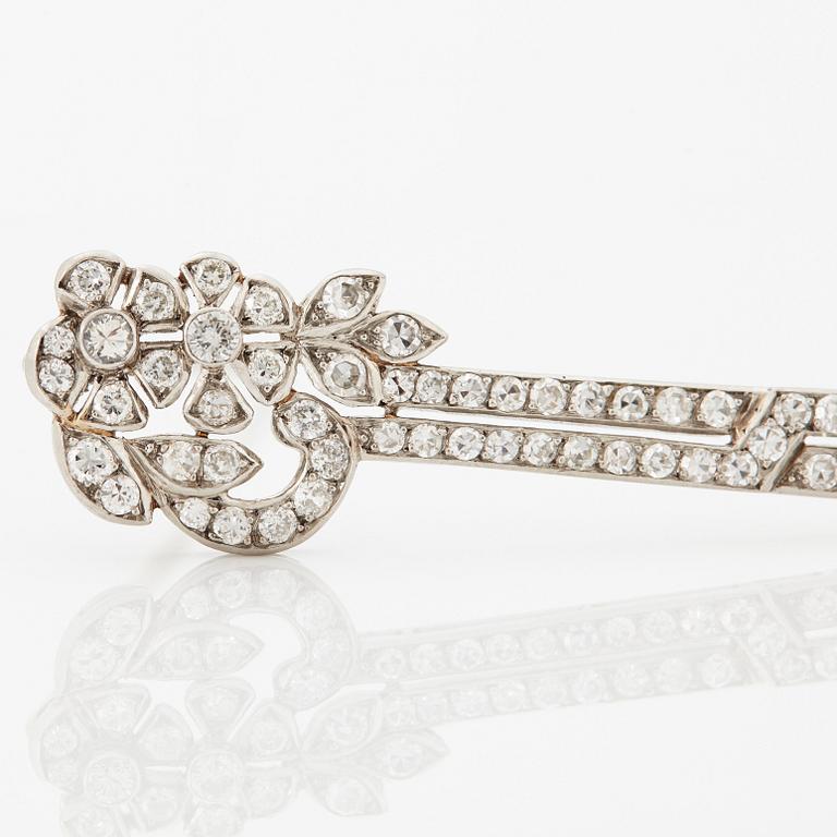 A platinum brooch set with round brilliant- and eight-cut diamonds.