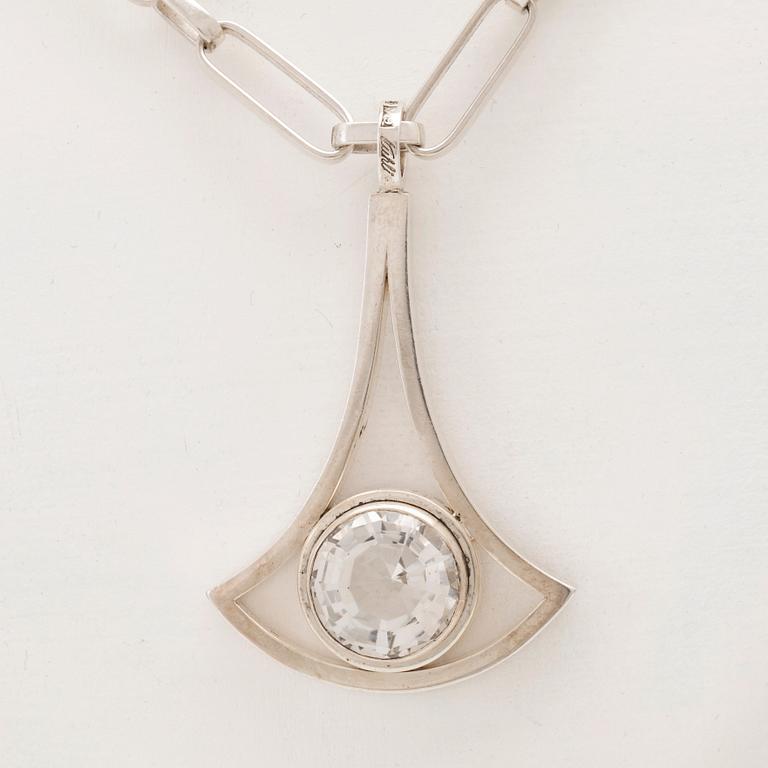 A silver necklace set with a round faceted rock quartz crystal by Göran Kuhlin Gothenburg 1971.