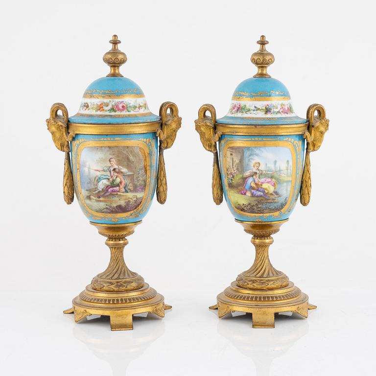 A French mantel clock, two urns and two depicters, second half of the 19th Century.