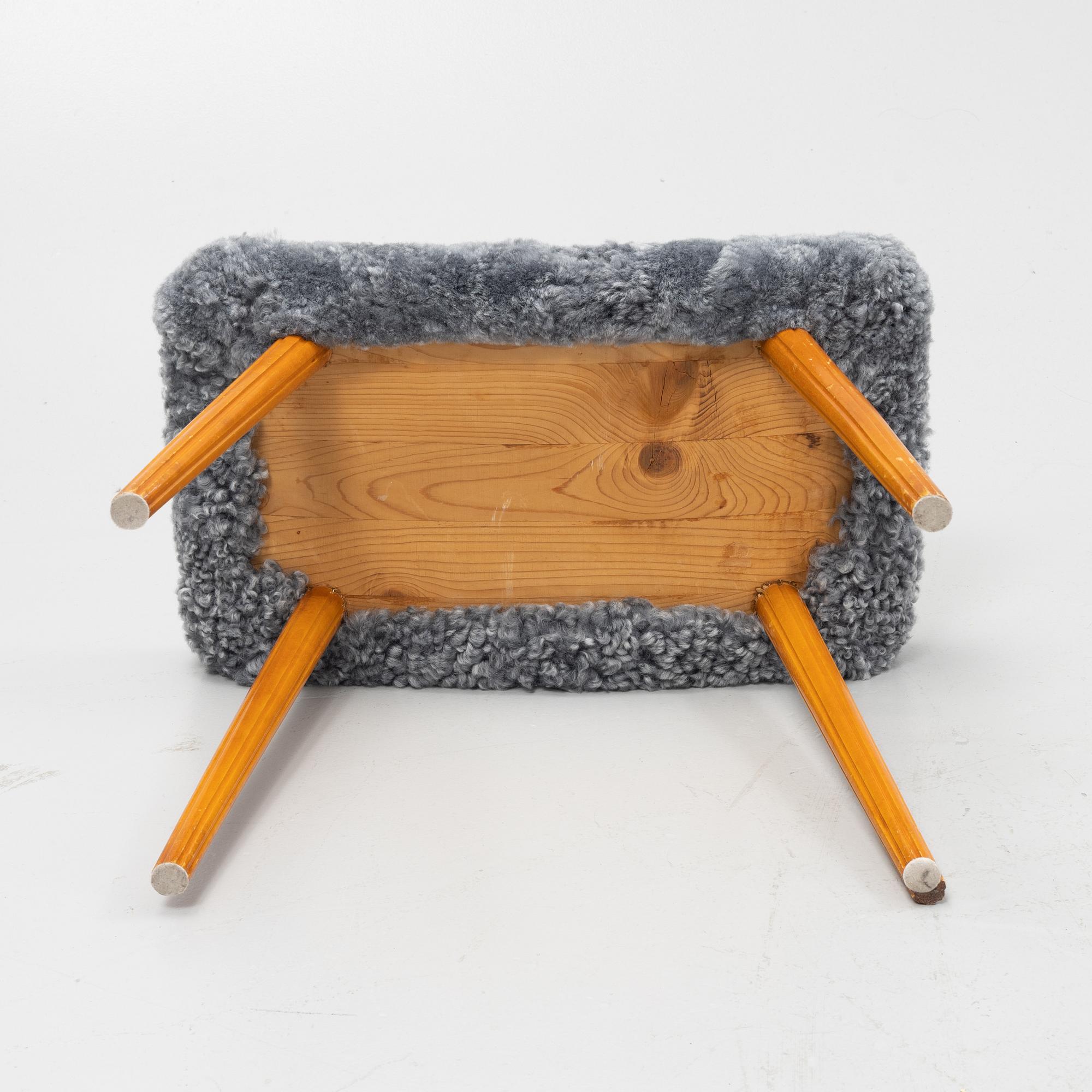 A mid 20th Century stool with new sheepskin upholstery.
