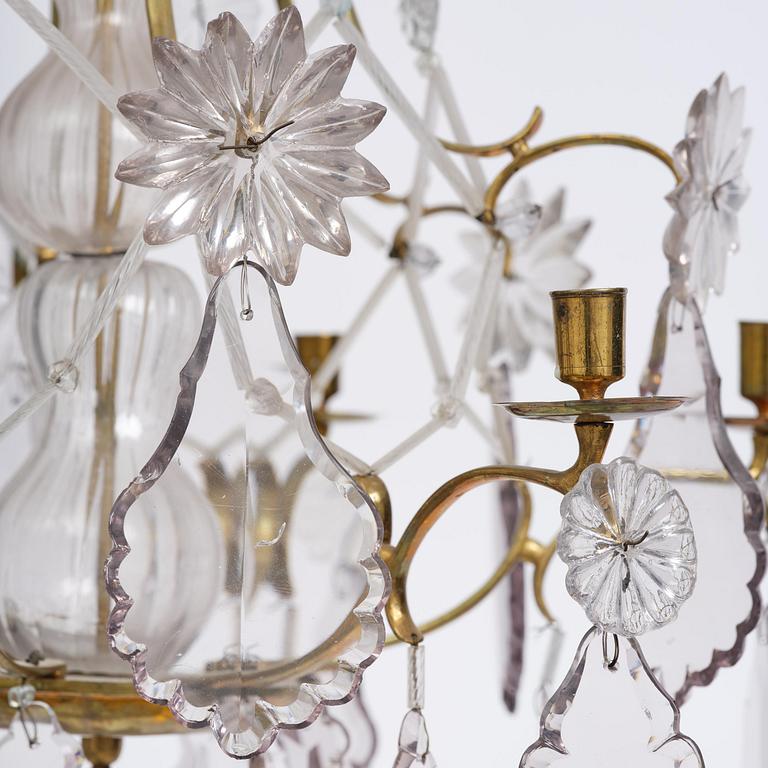 A near pair of rococo-style gilt brass and cut glass six-branch chandeliers, 19th century incorporating older elements.