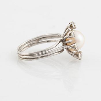 An 18K gold ring set with a cultured pearl and round brilliant-cut diamonds.