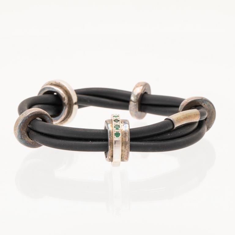 A rubber bracelet with rings 18K white gold silver and round brilliant-cut diamonds and emeralds, Jytte Lyhne Vejle.