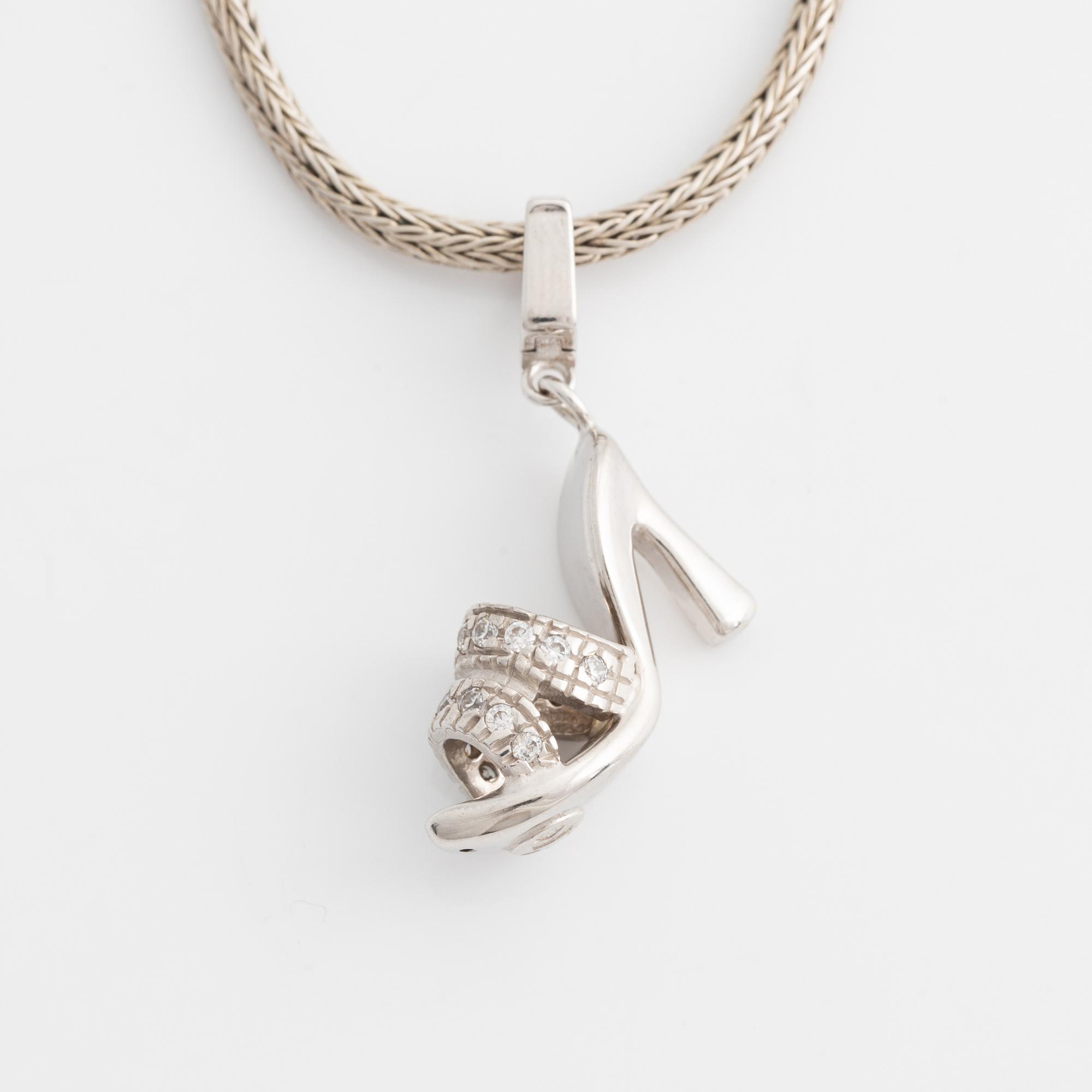 18K white gold shoe pendant with faceted white stones, silver chain.