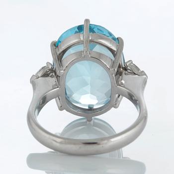 An 18K white gold ring set with a faceted topaz and two pear shaped brilliant-cut diamonds.