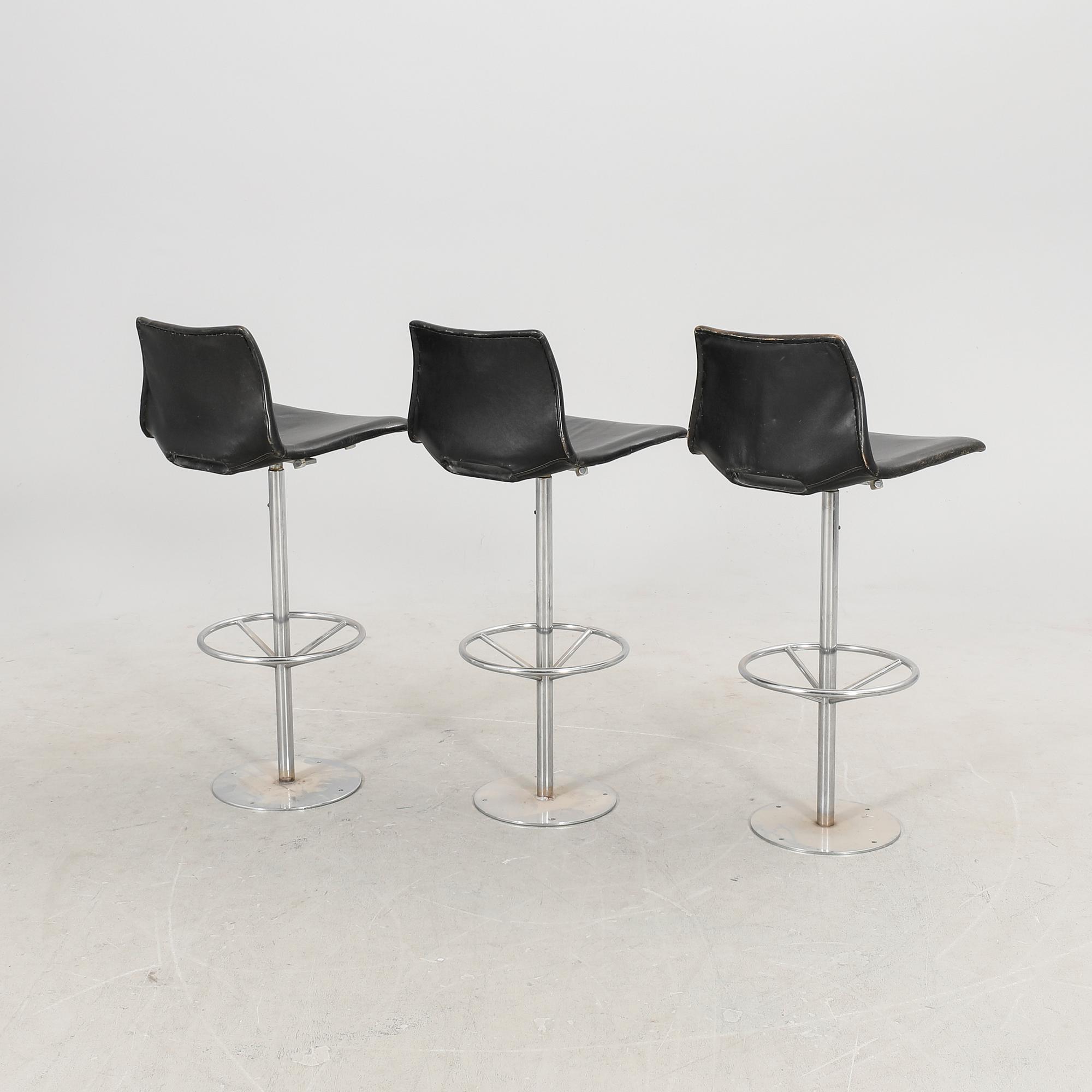A set of three late 20th century metal and leather bar stools.