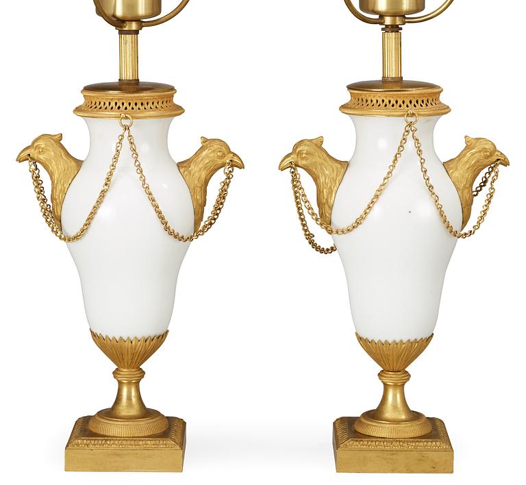 A pair of French circa 1800 gilt bronze and porcelain table lamps.