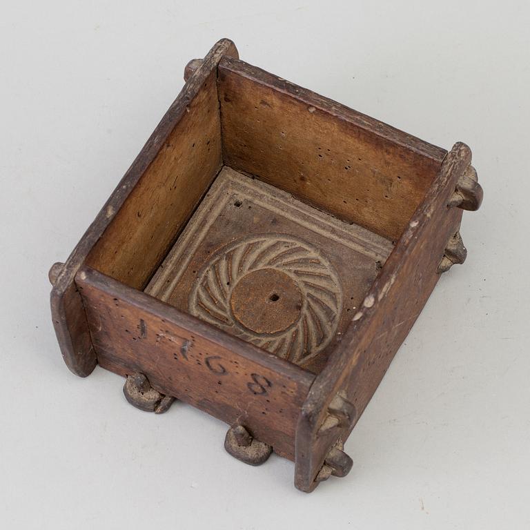 A cheese mould, dated 1768.