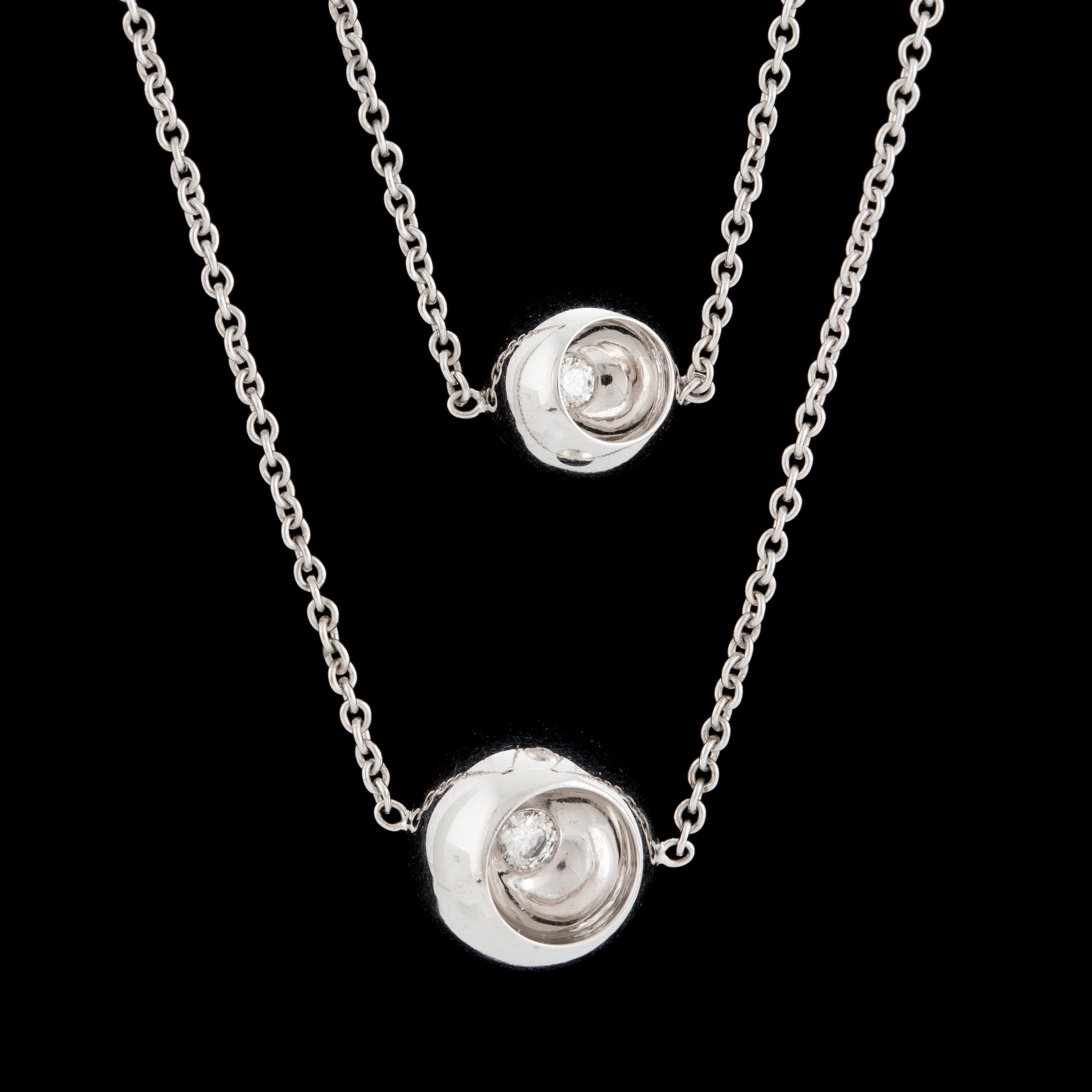 An 18K white gold 'Cave' necklace set with two round, brilliant-cut diamonds by Jacqueline Rabun for Georg Jensen.