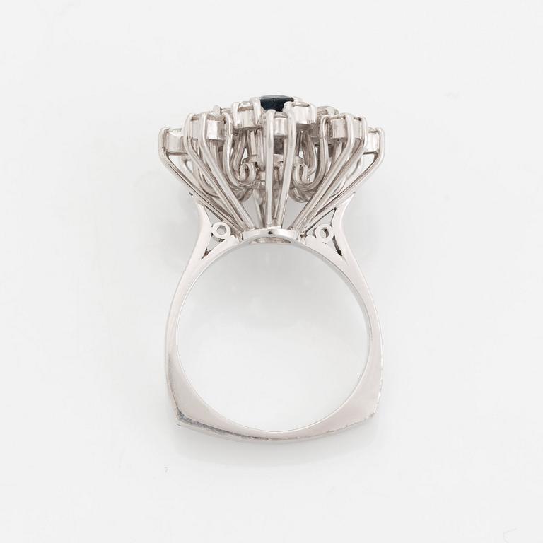 An 18K white gold ring set with a faceted sapphire and old-cut diamonds.