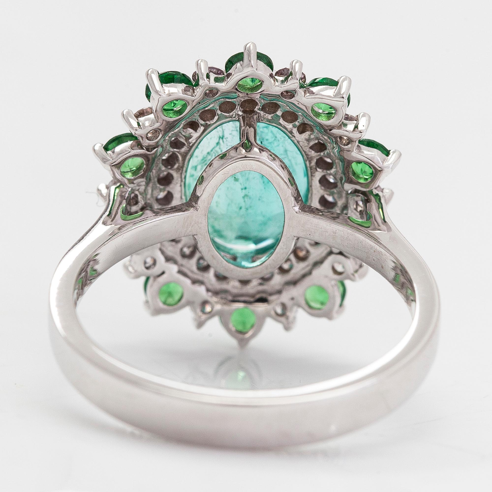 A 14K white gold ring with an emerald 2.40 ct, tsavorites 0.75 ct and diamonds ca 0.42 ct. With IGI certificate.