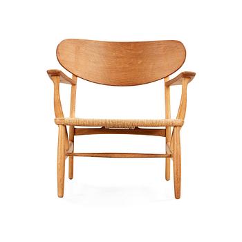 95. A Hans J Wegner 'CH-22' oak easy chair, Carl Hansen & Son, Odense, Denmark.