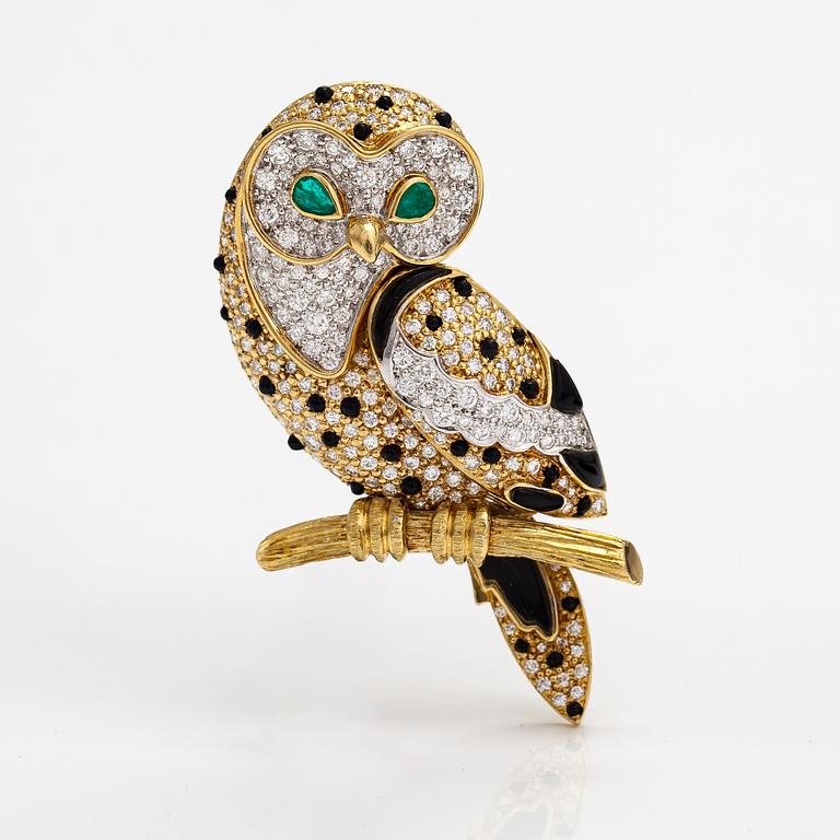 An owl brooch made of gold with diamodns ca. 4.00 ct in total, emeralds and onyx.