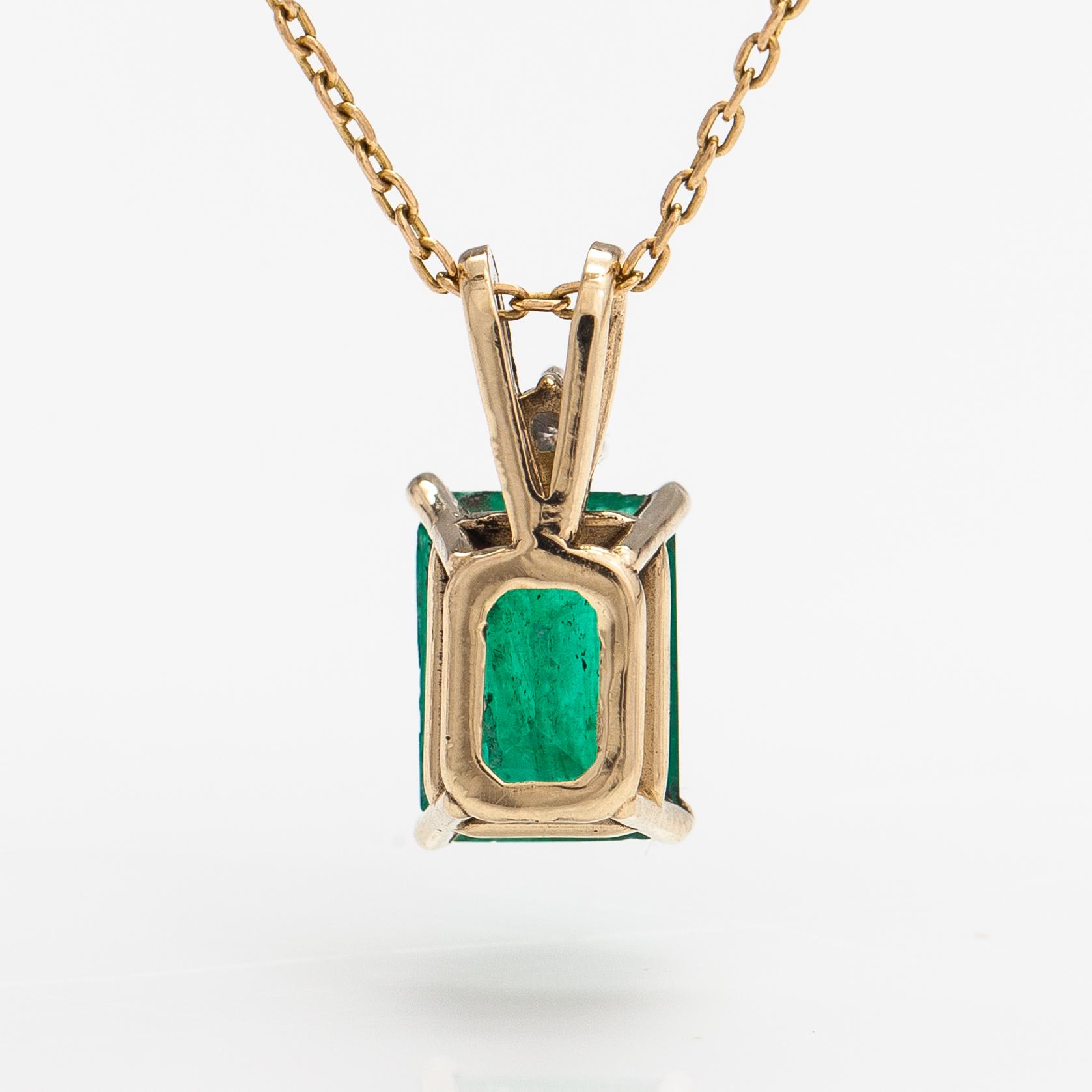 A 14K and 18K gold necklace with an ca. 2.22 ct emerald and a ca. 0.05 ct diamond.