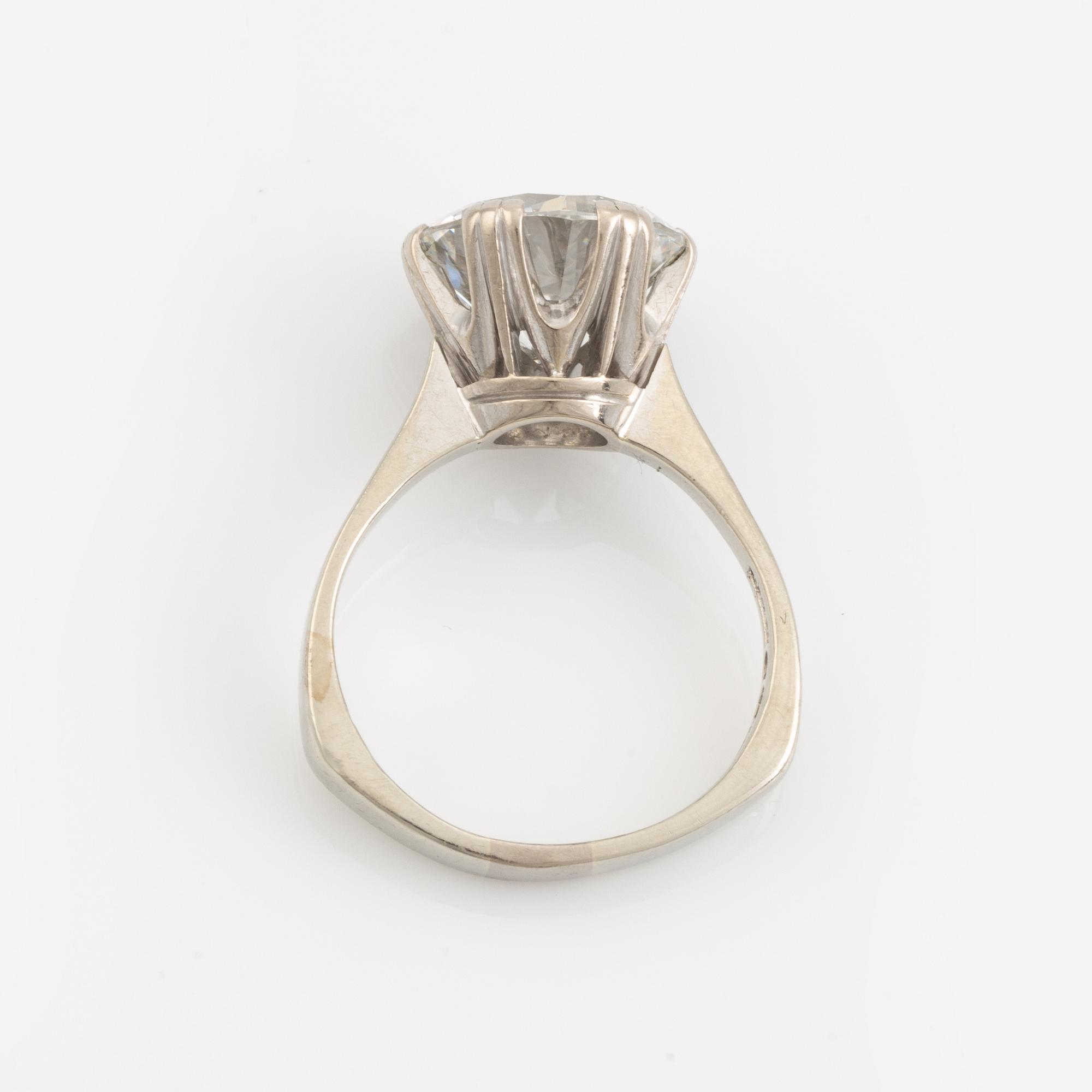 An 18K white gold ring set with a round brilliant-cut diamond.