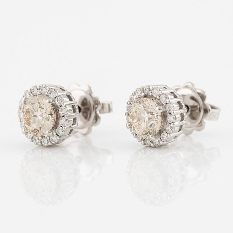 A pair of 18K gold earrings with round brilliant-cut diamonds.